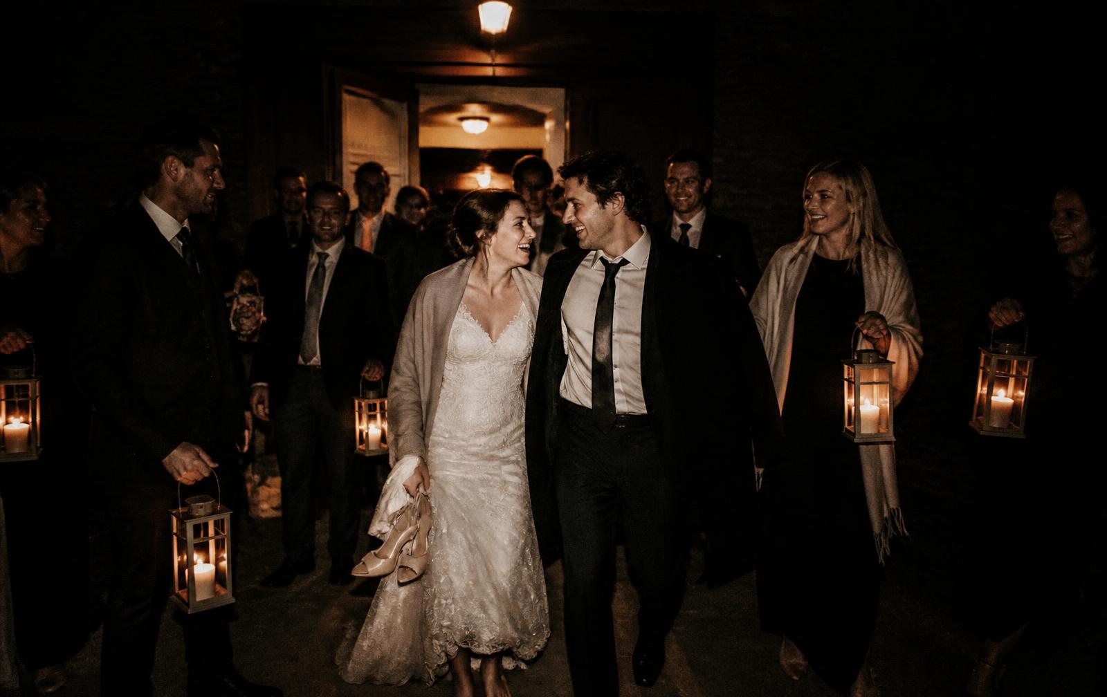 Last call on a wedding dance floor, guests mid-shout under warm light